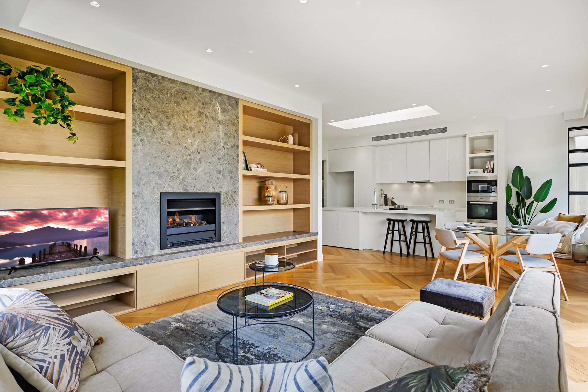 Interior image of Barnsbury Deepdene apartments with a grey couch near a fireplace and dining area