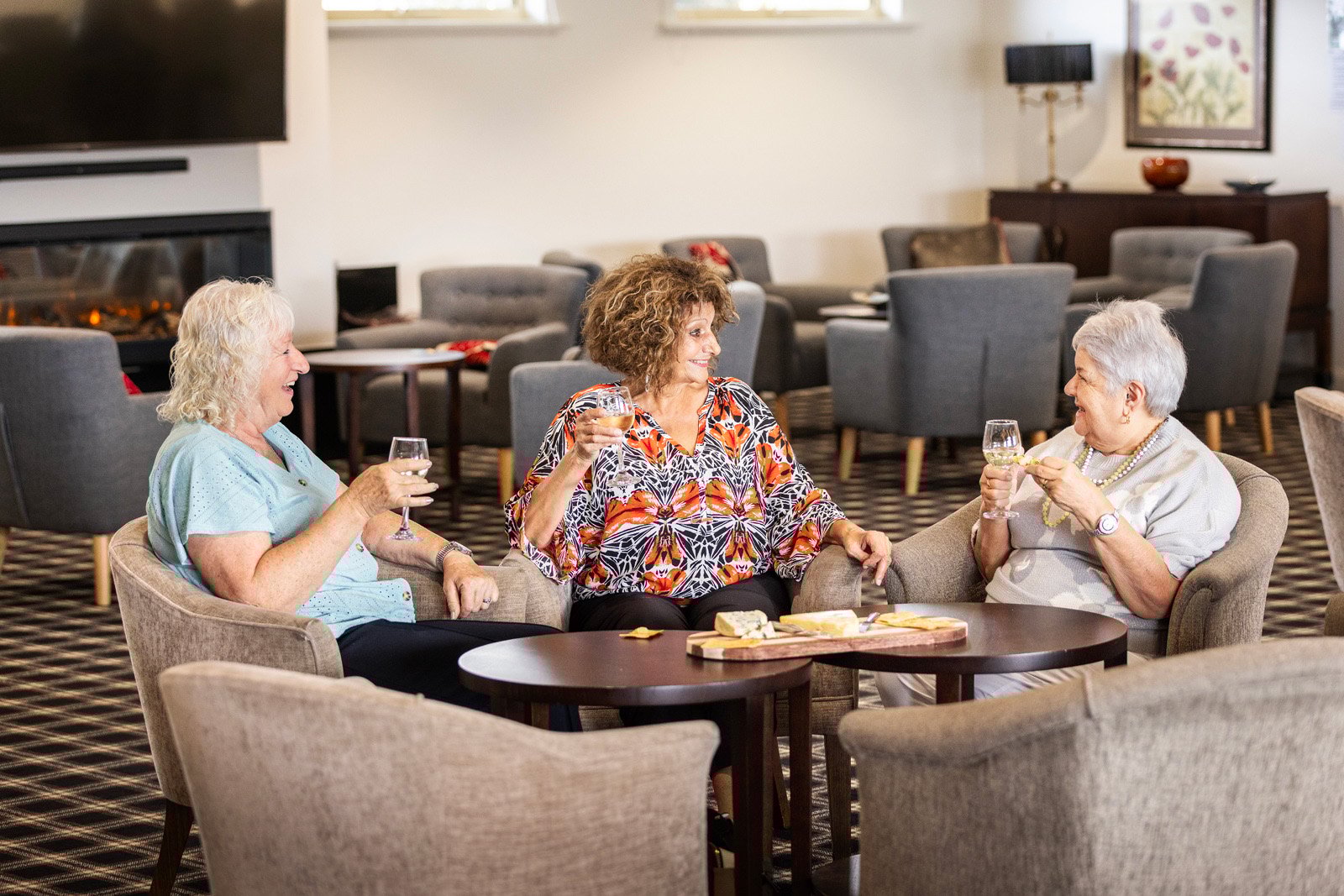 Three older woman sitting on lounges and talking